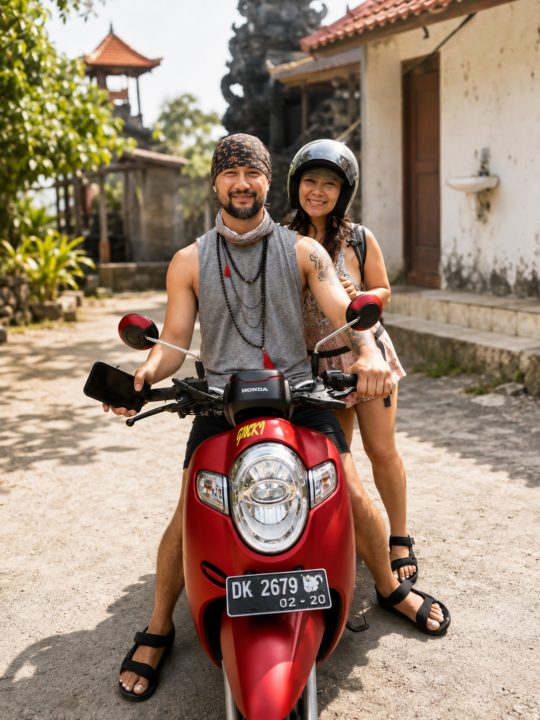 Couple on a red Honda scooter near a Balinese temple
